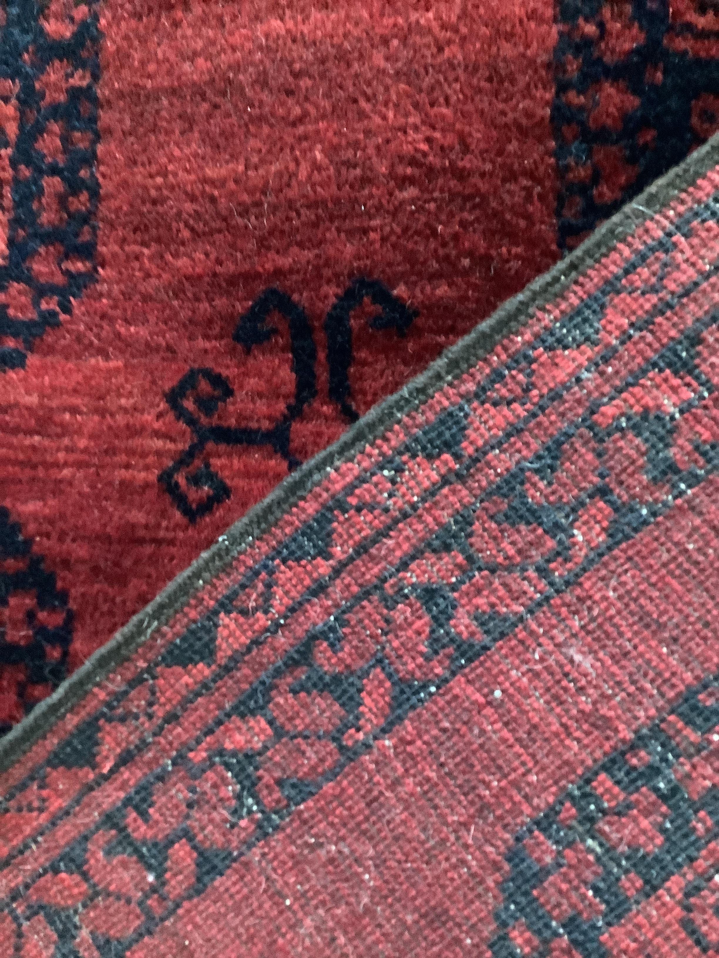 An Afghan red ground rug, 162 x 116cm